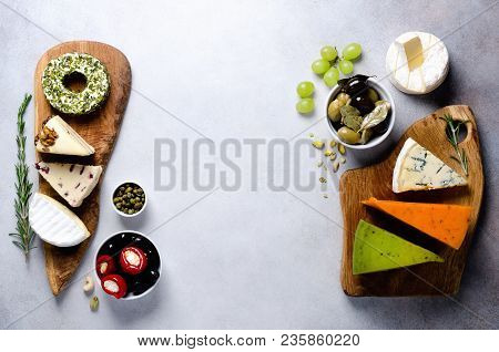 Assortment Of Hard, Semi-soft And Soft Cheeses With Olives, Grissini Bread Sticks, Capers, Grape, On