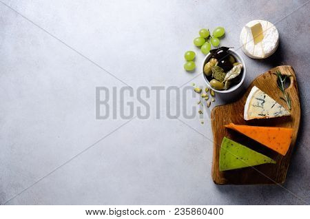 Assortment Of Hard, Semi-soft And Soft Cheeses With Olives, Grissini Bread Sticks, Capers, Grape, On
