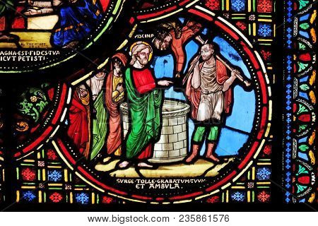 PARIS, FRANCE - JANUARY 09: Jesus heals a lame man, stained glass window from Saint Germain-l'Auxerrois church in Paris, France on January 09, 2018.