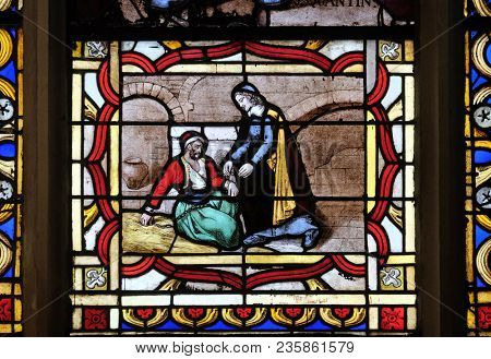 PARIS, FRANCE - JANUARY 09: Saint Vincent de Paul helps a prisoner, stained glass window from Saint Germain-l'Auxerrois church in Paris, France on January 09, 2018.