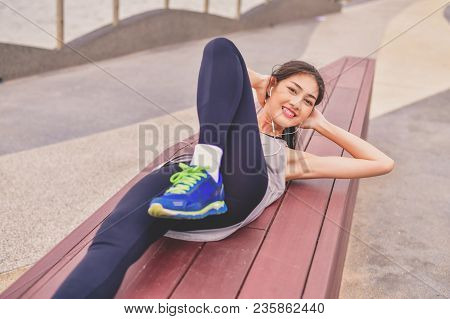 Sports Concept. Beautiful Girl Is Exercising On The Beach With Warm Up. Beautiful Girl Is Happy To E