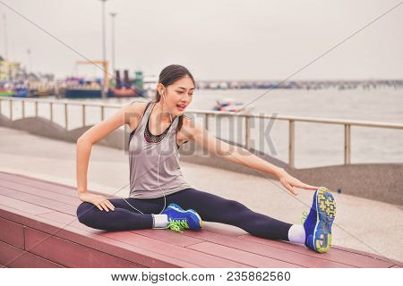 Sports Concept. Beautiful Girl Is Exercising On The Beach With Warm Up. Beautiful Girl Is Happy To E