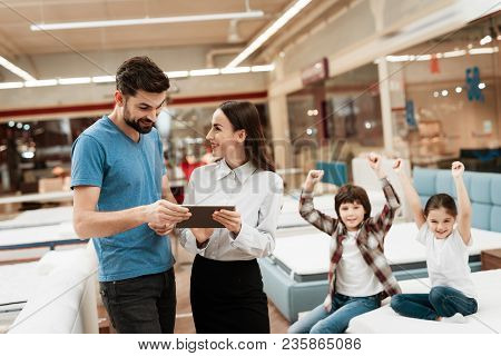 Lovely Girl Consultant With Confident Man Make Out Purchase Of Mattress In Store. Confident Family M