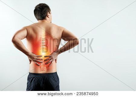 Rear View, The Man Holds His Hands Behind His Back, Pain In The Back, Pain In The Spine, Highlighted