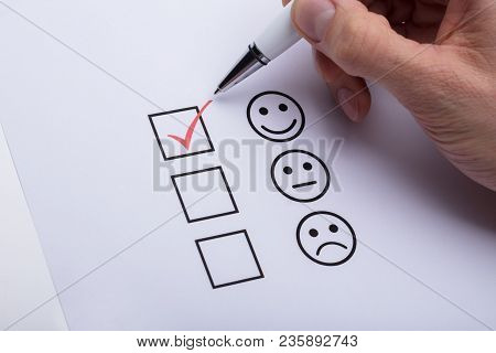 Person's Hand Ticking Off Checked Box