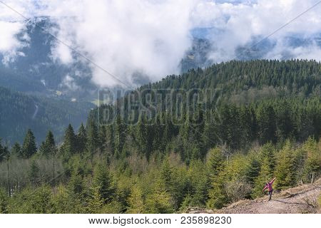 Landscape With The Hornisgrinde Mountains, Covered With Green Fir Forest And A Girl Enjoying The Vie