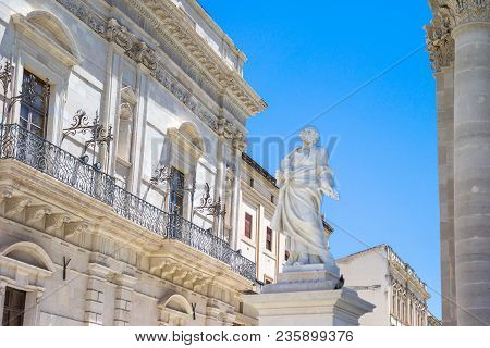 Italy, Sicily, Siracusa, Ortigia District, A Statue Of The Cathedral  With The Senato Palace In The 