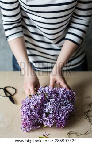 Woman Hands Making Bouquet Of Lilac In A Pot On The Table.