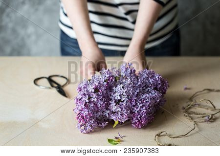 Woman Hands Making Bouquet Of Lilac In A Pot On The Table.