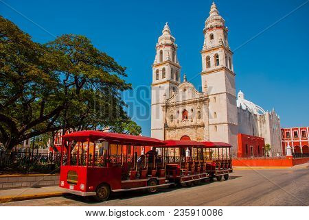 Campeche, Mexico Independence Plaza, Tourist Trains And Cathedral On The Opposite Side Of The Square