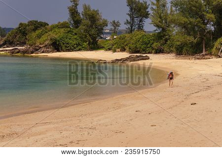 A Man Walking Away On The Beach Of Kouki In Nago On The Island Of Okinawa In Japan. Beautiful Turquo