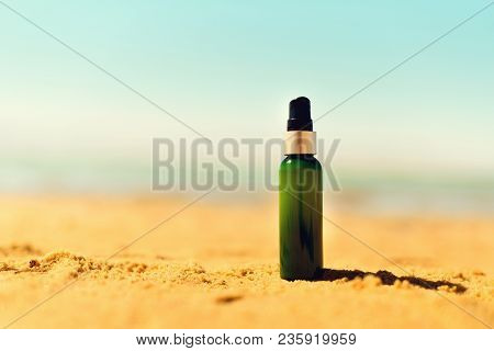 Bottle Of Sunscreen In Sand Against Sea Background With Copyspace. Vacation And Travel Wallpaper. Sk