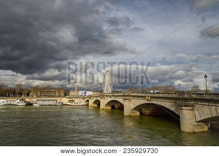 Paris, France. March 30, 2018. Scenic View On River Seine. Ferris Wheel Roue De Paris And Cloudy Sky