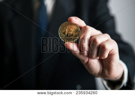 Golden Bitcoin In A Man Hand, Digitall Symbol Of A New Virtual Currency. Man Recived Money From Bitc