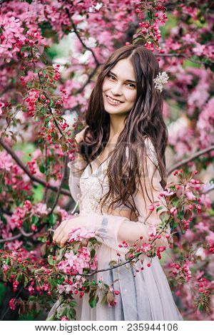 Beautiful Brunette Girl Bride In Boudoir Lace Transparent Dress Smile Near The Tree Blossoms With Pi