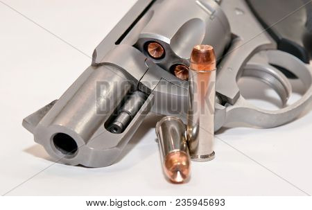 A .357 Magnum Revolver Loaded With Hollow Point Bullets With Two Shown Next To The Gun With A White 
