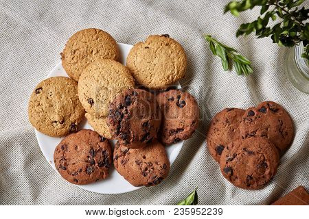 Side View Of A Plate Of Chocolate Chip Cookies On A White Plate Homespun Tablecloth Illuminated With