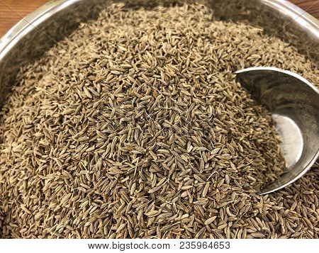 Pile Of Cumin Seeds With Metallic Scoop Close Up.