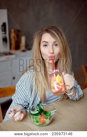 Happy Woman Sipping Fresh Summer Lemonade. Caucasian Young Girl 20-25 Years Old Sitting At The Table
