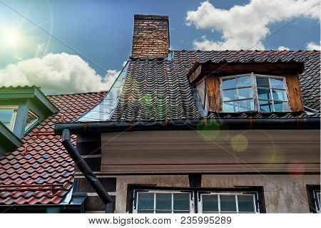 Roofs Of Old Houses In Skarnu Iela Street In Riga, Latvia Against Blue Sky With Awesome Lens Flares.