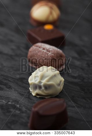 Luxury Chocolate Candies Selection On Black Marbel Board. White, Dark And Milk Chocolate Assortment.