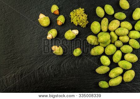 Wasabi Coated Peanuts On Slate Board. Japanese Wasabi Spice. Green Wasabi Peanuts On A Black Plate O