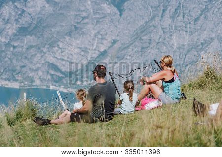 Monte Baldo, Italy - August 8, 2019: Hiker Sit And Watch Over Lake Garda On Top Of Monte Baldo