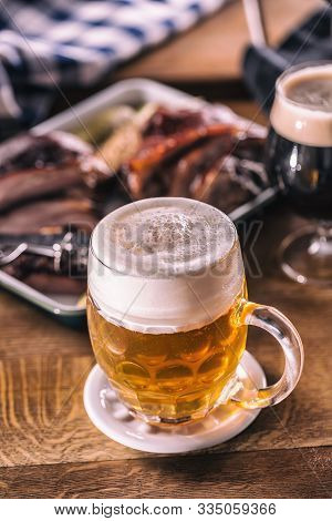 Glass Of Light Beer In Pub Or Restavurant On Table With Delicoius Food.