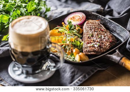 Glass Of Dark Beer In Pub Or Restavurant On Table With Delicoius Food.