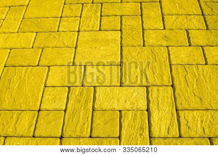 Geometric Bright Yellow Background With Artificial Stone Paving Made Of Square Blocks Of Different S