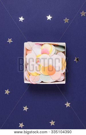 Colorful Confetti In A Box On A Blue Background With Sprickle Silver Stars.