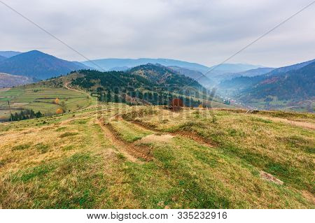 Carpathian Rural Area In Autumn. Wonderful Landscape In Mountains On A Hazy Day. Village In The Dist