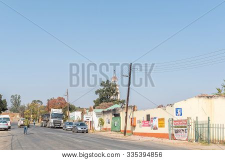 Machadodorp, South Africa - May 22, 2019: A Street Scene, With A Burnt Down Building, People And Veh