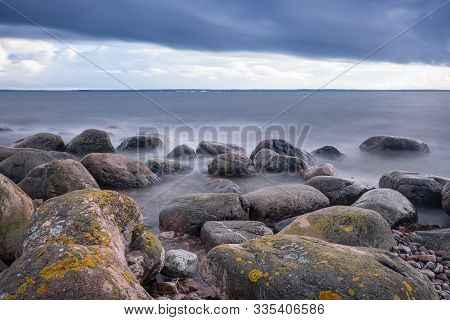 Boulders, Forest, Shore, Evening Light, Sunset, Clouds, Blue Sky And Rainbow On The Baltic Sea. Mohn