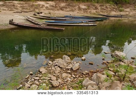 Old Wooden Boats On A Beach. Traditional Boats Canoe On Coastline Of Nam Hinboun River (nam Hin Bun)