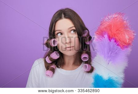 A Beautiful Brown-haired Woman With Green Eyes In Pink Curlers Looks Away. Pipidaster. Cleaning The 