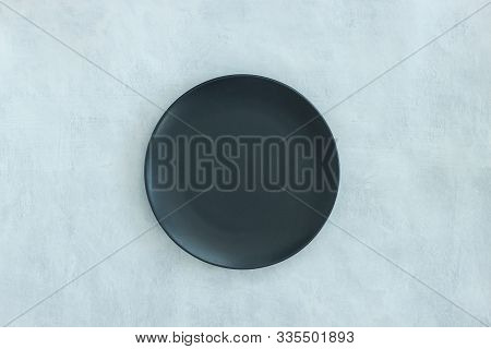 Empty Black Plate On Dark Stone Grey Kground. Flatlay, Top View. Mock Up Food Background