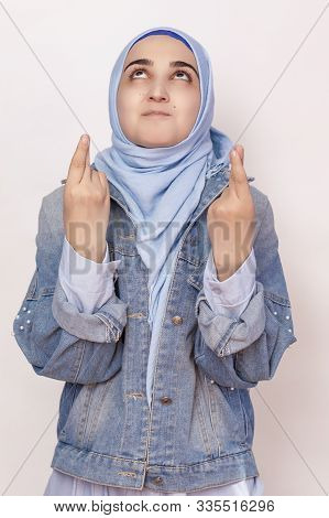 Happy Muslim Woman In Hijab With Fingers Crossed, Waiting For Magic To Happen. Waiting For Special M