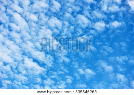Blue sky with lots small white fleecy clouds - textured background                               