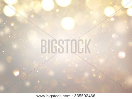 Christmas glowing Golden Background. Christmas lights. Gold Holiday New year Abstract Glitter Defocused Background With Blinking Stars and sparks. Blurred Xmas Bokeh. Greeting card art design