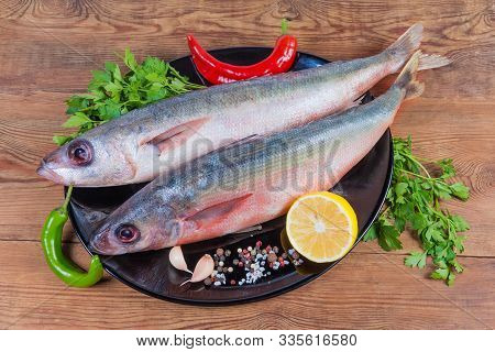 Two Carcasses Of Raw Redbait Fish, Also Known As Bonnetmouth Or Emmelichthys Nitidus, Parsley, Chili