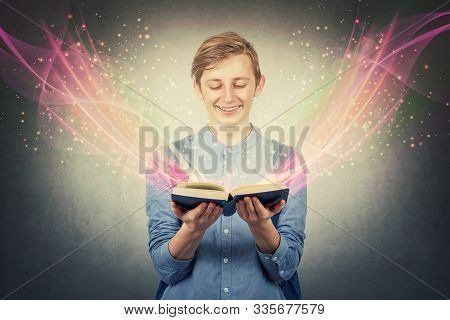 Overjoyed Boy Teenager Smiling As Holding A Opened Bewitched Textbook. Magic Book Concept, Different