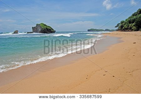 Waves Chasing On The Beach With White Sand. Blue Sky On Sunny Day