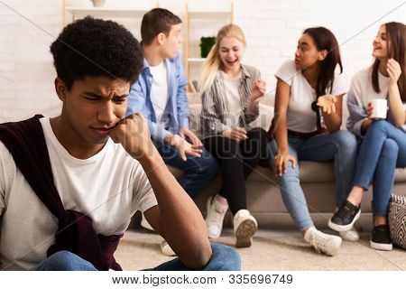 Upset Bullied Guy Sitting Alone, Excluded By Bad Friends And Suffer From Unfair Attitude