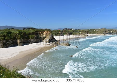 Beach With Cliff, White Sand And Waves. Viveiro, Lugo Province, Spain.