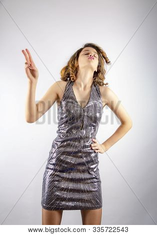 Vivacious Dark-haired Dancing In A Brilliant Miniskirt Dress, Studio Portrait On Gray.