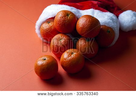 Christmas Tangerines In A Santa Hat On An Orange Background, Christmas Fruits, Festive Symbol