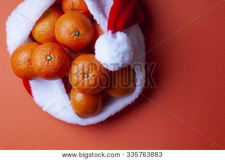 Christmas Tangerines In A Santa Hat On An Orange Background, Christmas Fruits, Festive Symbol