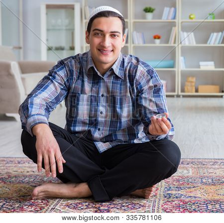 Young muslim man praying at home