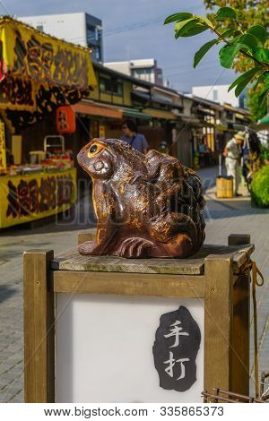 Matsumoto, Japan - October 2, 2019: Symbolic Frog Figure, In The Historic Nakamachi District, With V